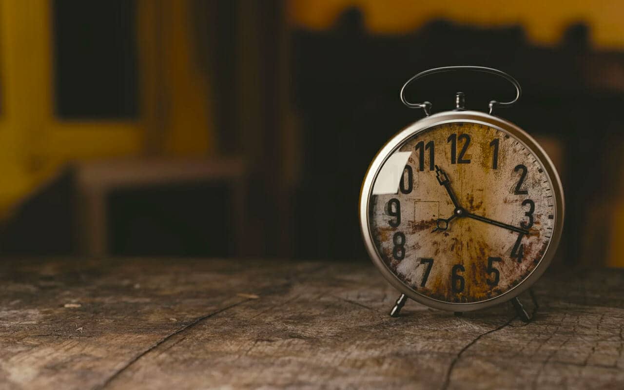 a clock on a wood desk