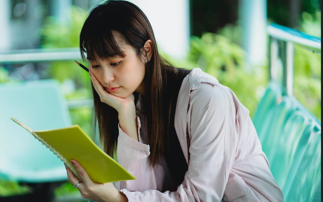 a girl is thinking and writing notes