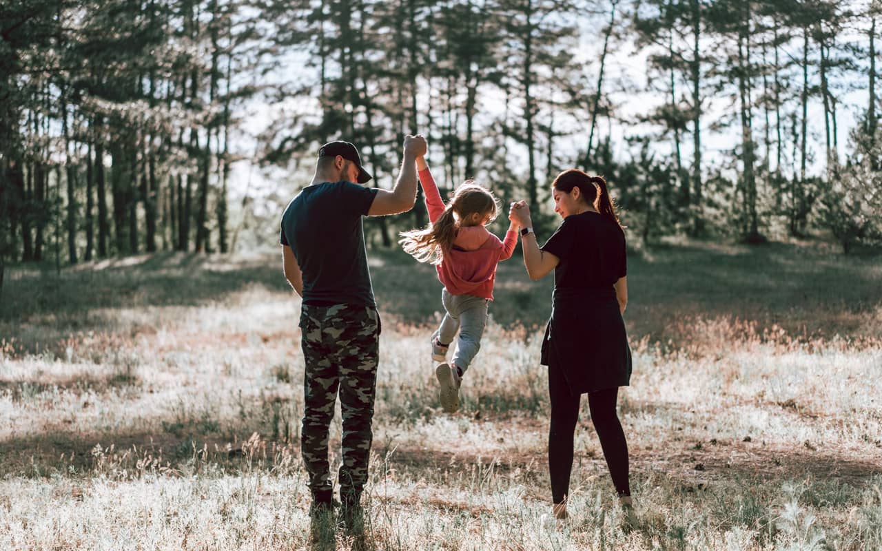 a happy family walking in a park