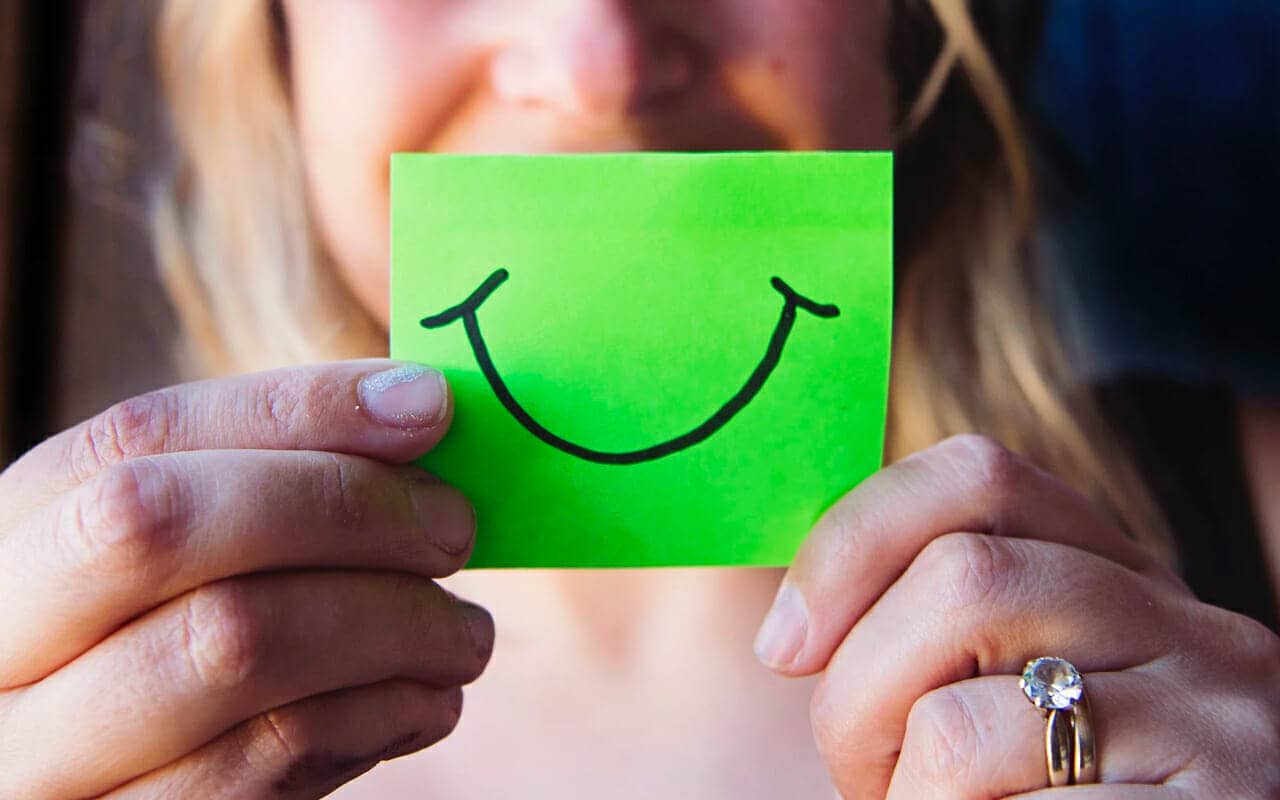 a woman has a green paper with a smile