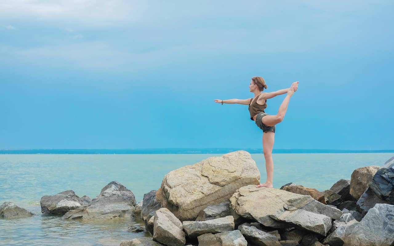 a woman is balancing on rocks