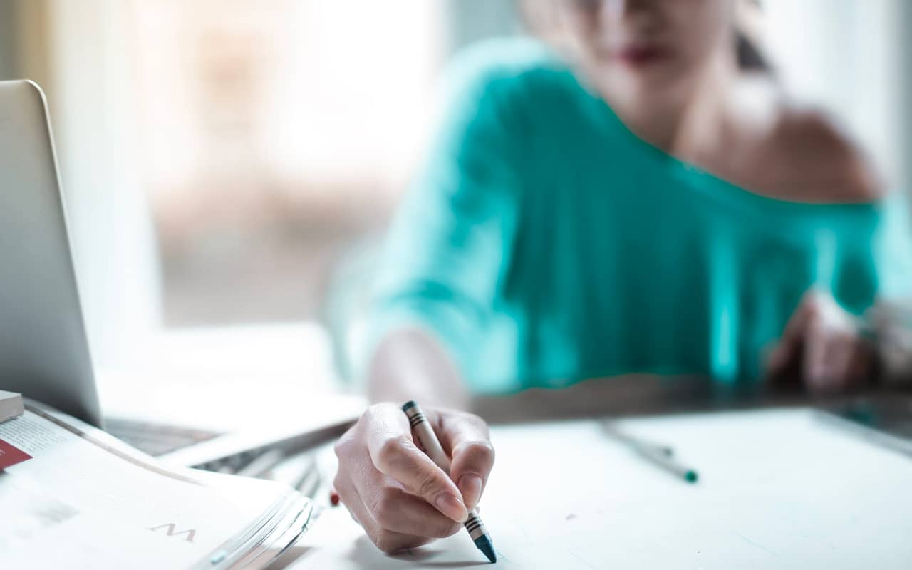 a woman is making plans on a paper