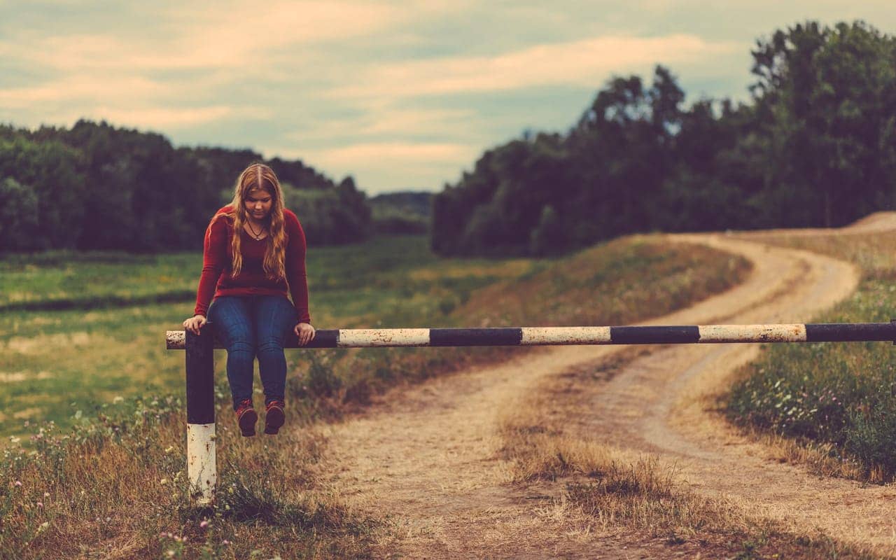 a woman is sitting on a barrier