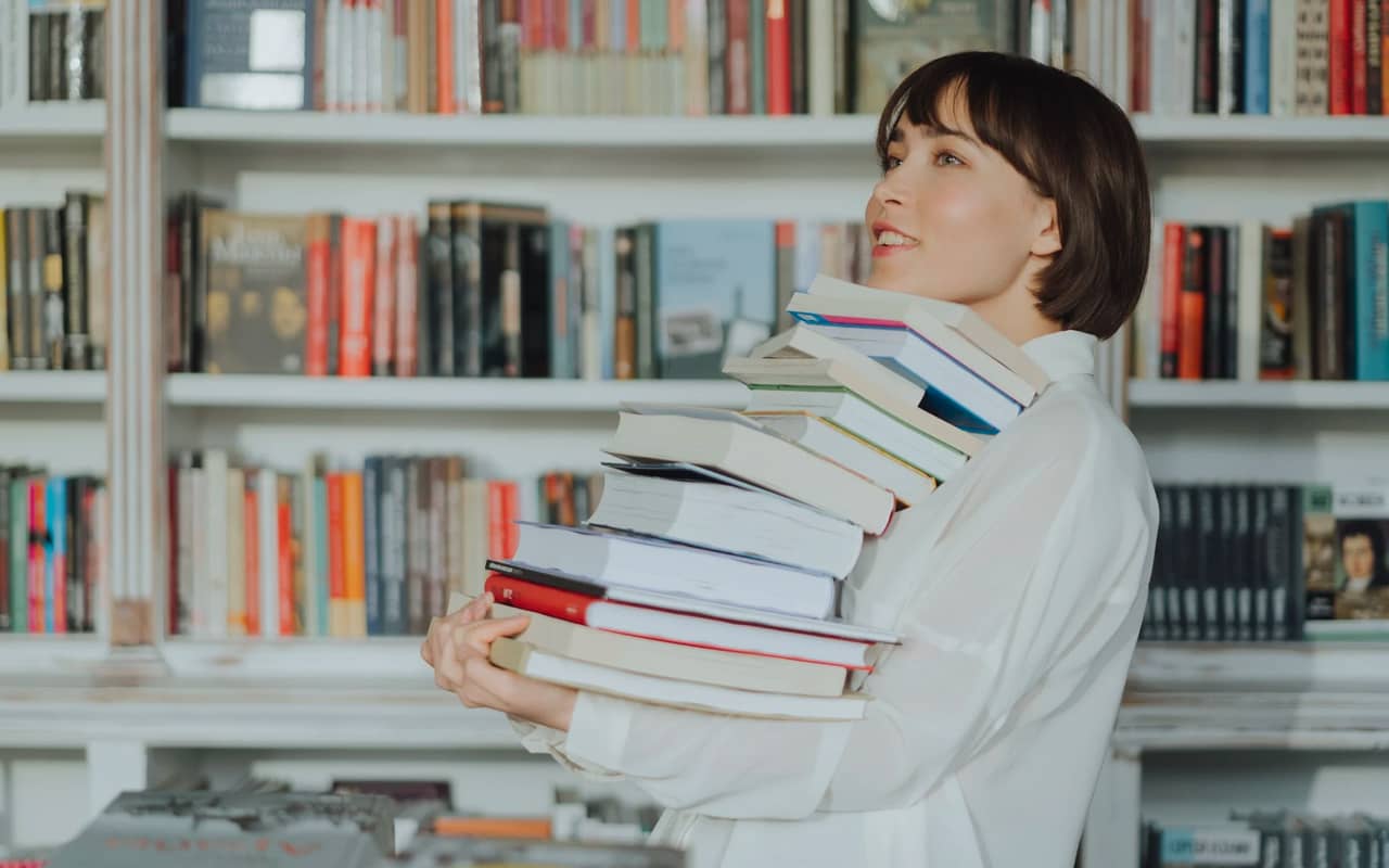 a woman is taking lots of books