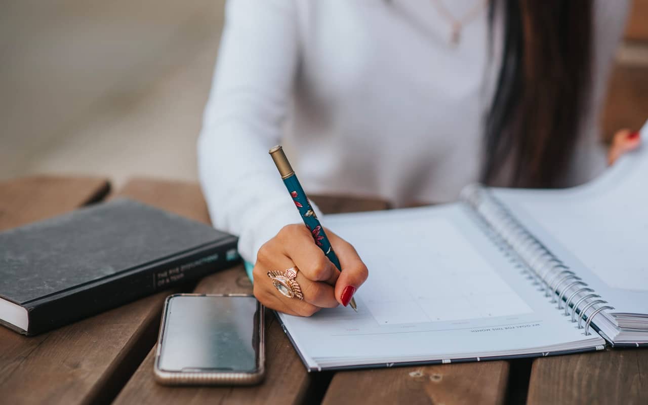 a woman is writing her journal