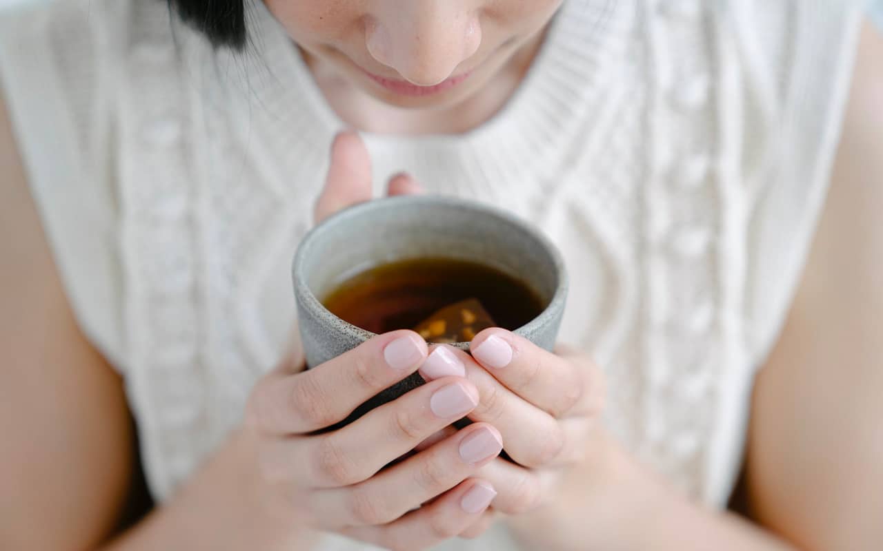 a woman smells the tea