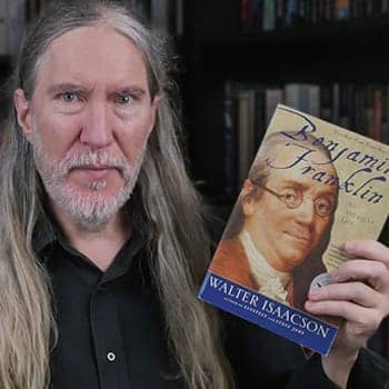 Benjamin Franklin as a polymath feature image of Anthony Metivier holding a Franklin biography by Walter Isaacson