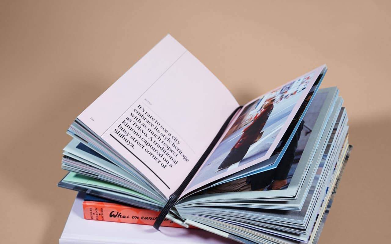 An open book with a bookmark sits on top of a stack of books. Anthony's dissertation defense was helped by his ability to mentally "bookmark" what he had written.