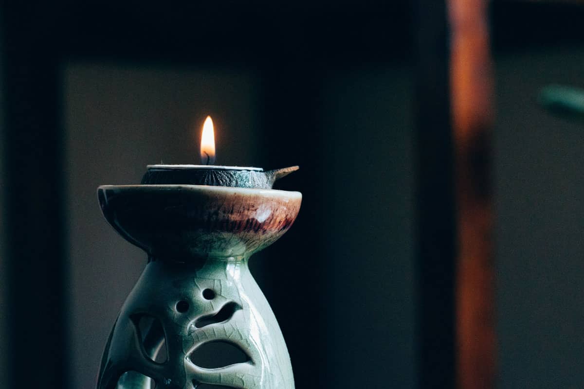 A candle burns in a pottery candle-holder. A candle can be used for the single point of focus during dharana (concentration).