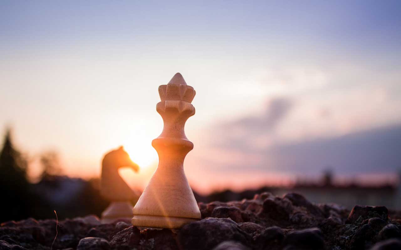 A closeup of chess pieces, including a queen and a knight.