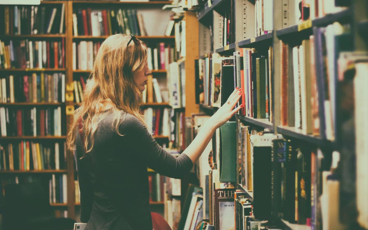 woman selecting books from a shelf
