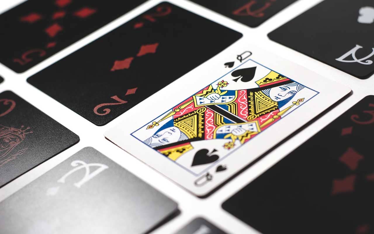 Cards on a table, with the Queen of Spades face up.