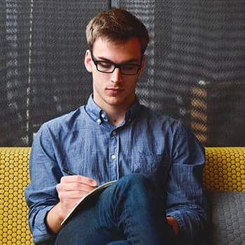 self study lsat tips feature image of a young man writing on a pad