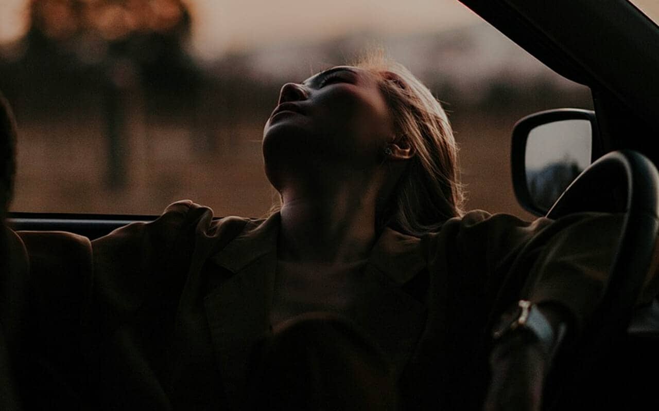Woman resting in car to illustrate how memory bias is usually unconscious