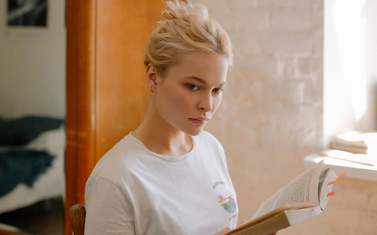 white t shirt woman thinking and reading
