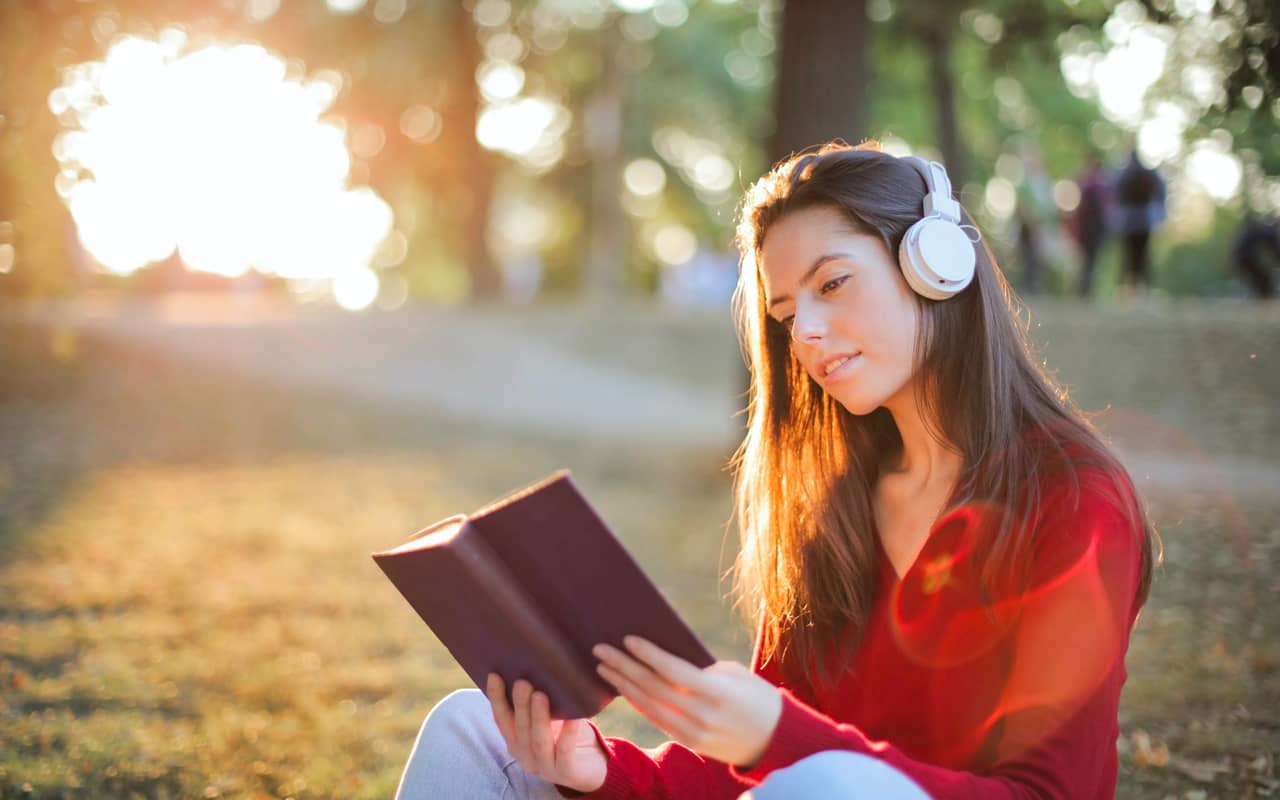 woman wears red cloth reading and listening